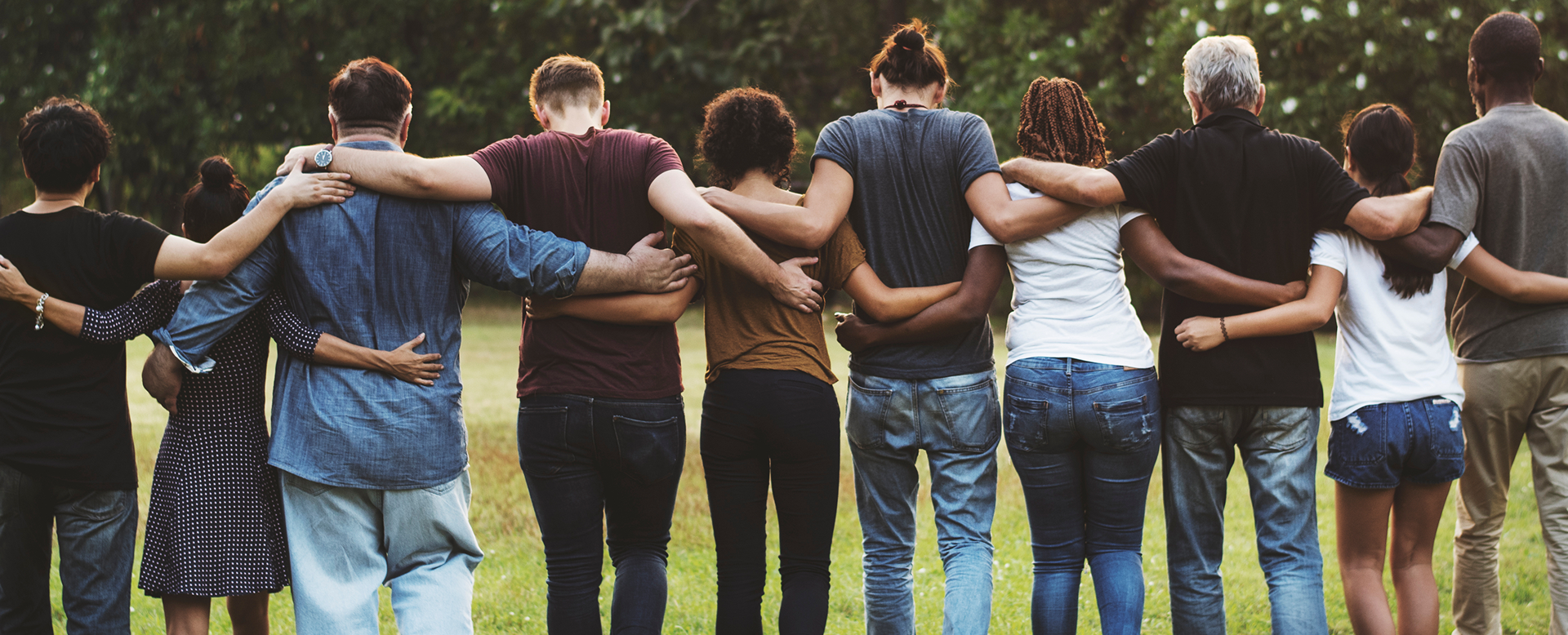 Group of friends standing arm in arm outdoors.