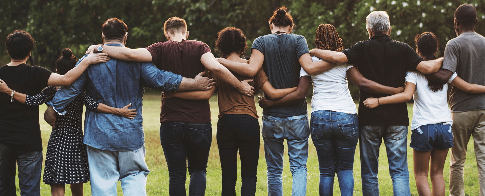 Group of friends standing arm in arm outdoors.